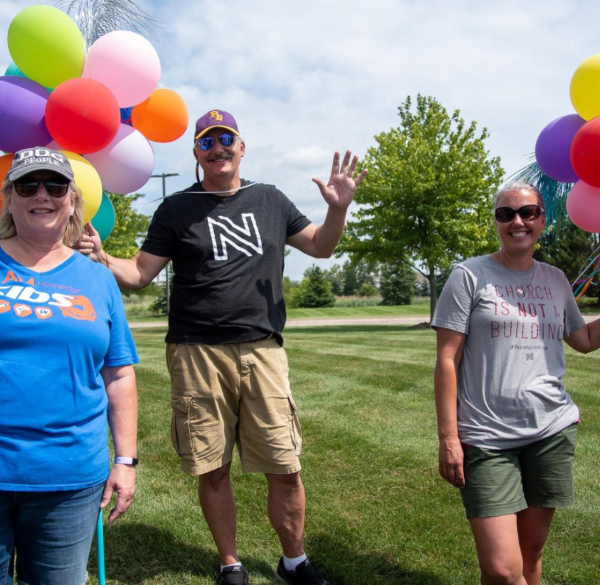 Three smiling volunteers with balloons